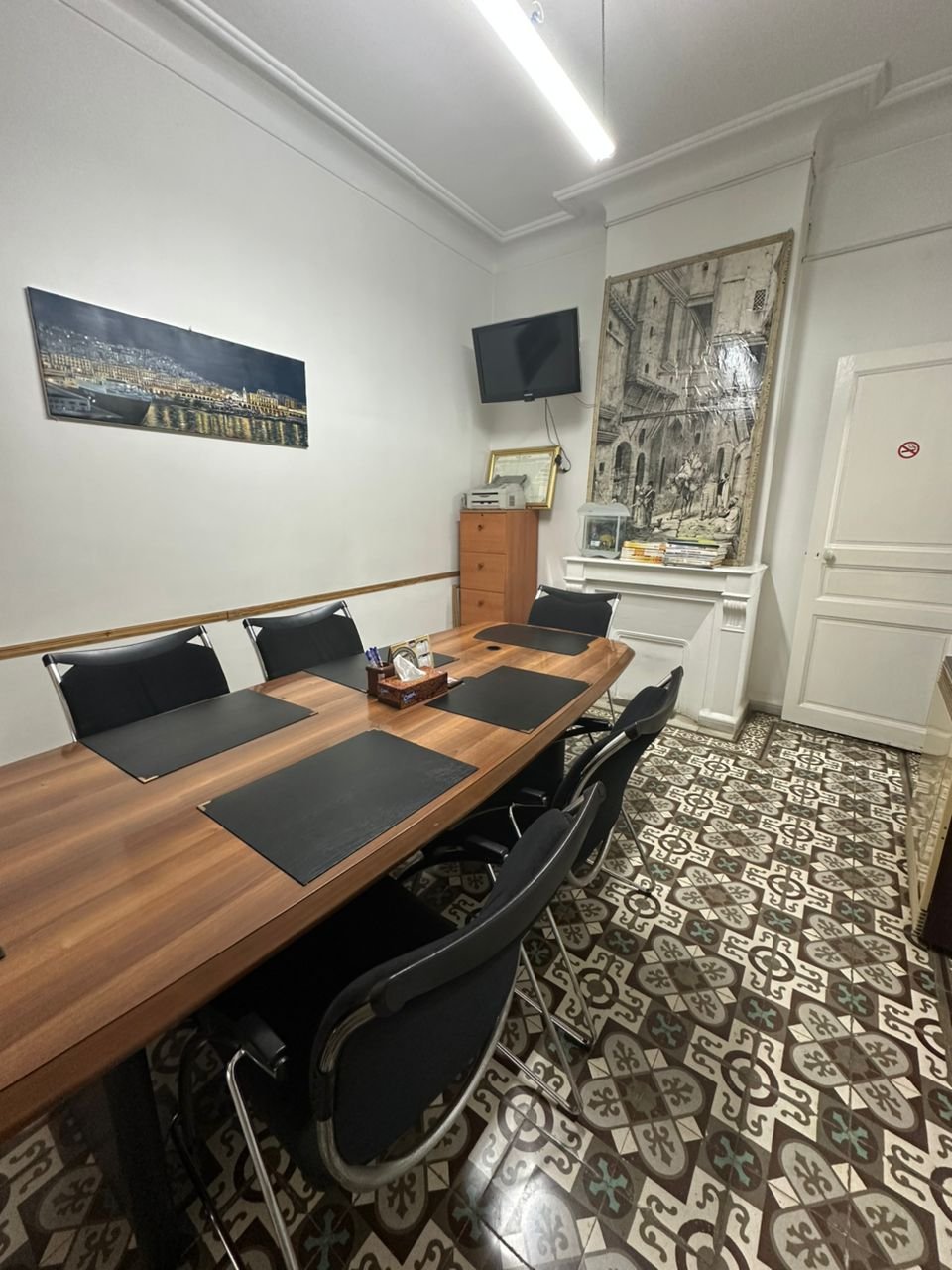 Salle de réunion avec grande table en bois et carreaux de ciment traditionnels